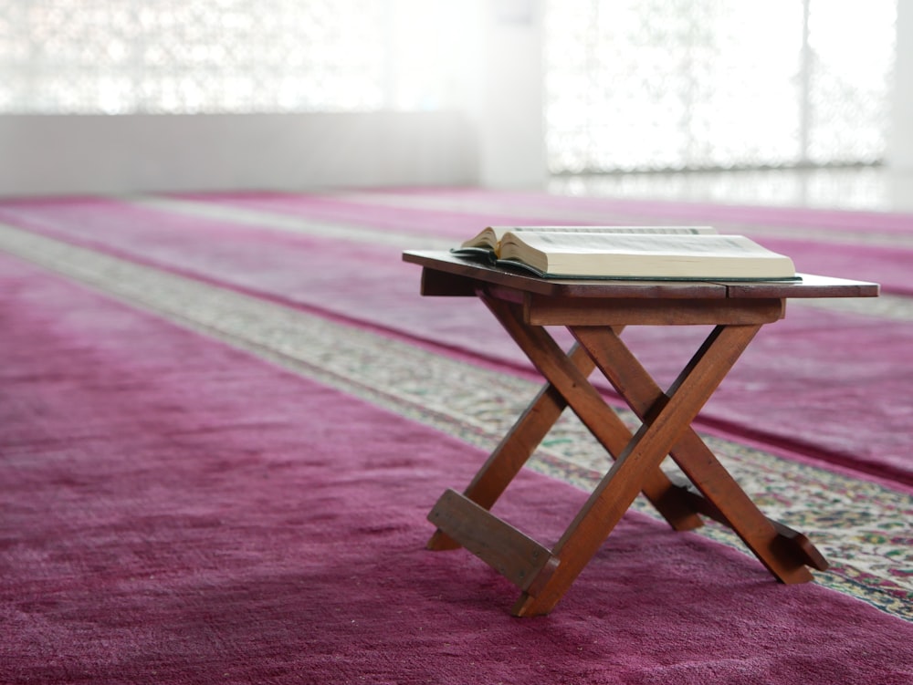 a small wooden table with a book on top of it