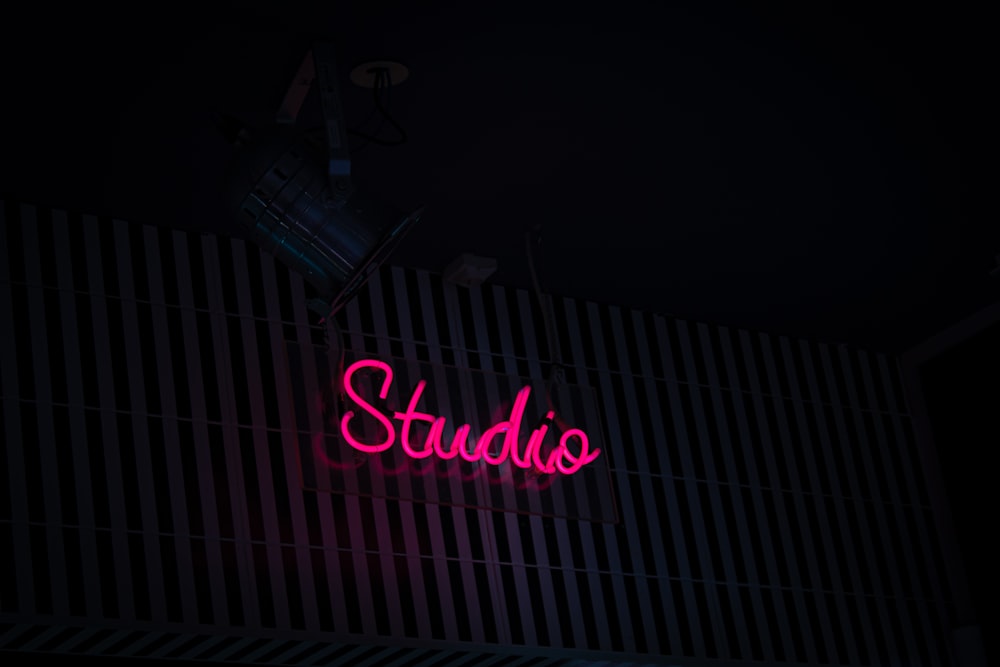 a neon sign that reads studio on the side of a building