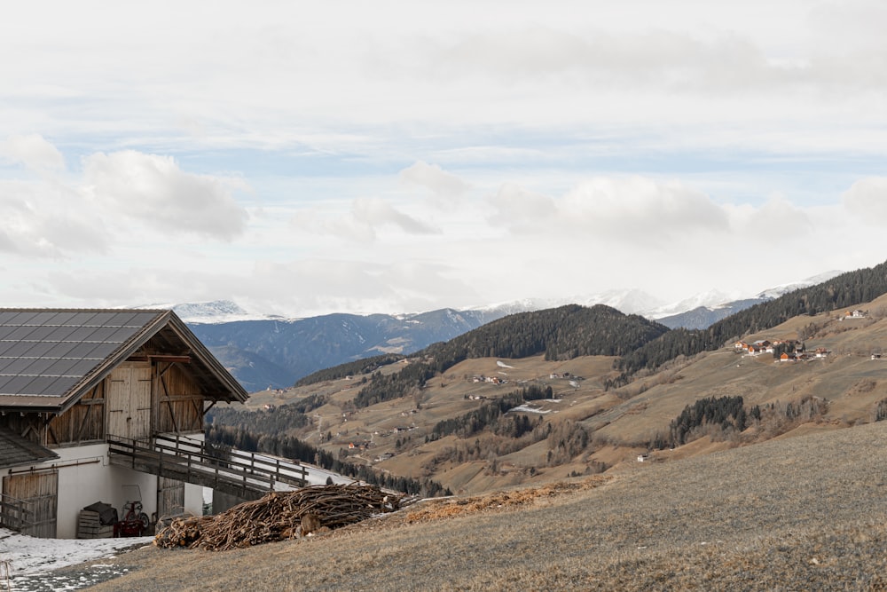 a house on a hill with mountains in the background