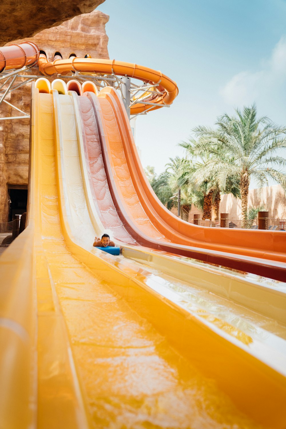 a man riding a water slide in a water park