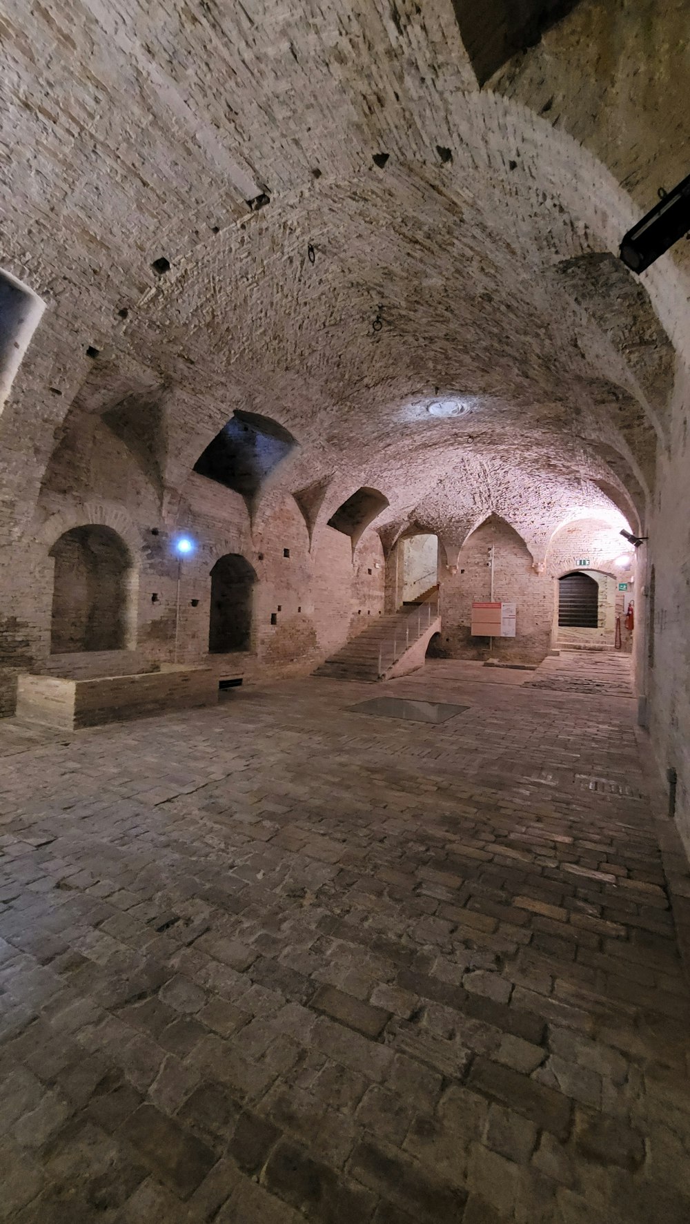 un grande tunnel di pietra con un orologio sul muro
