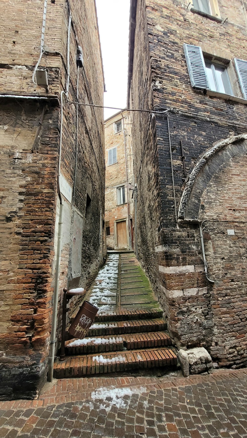 a narrow alleyway between two brick buildings