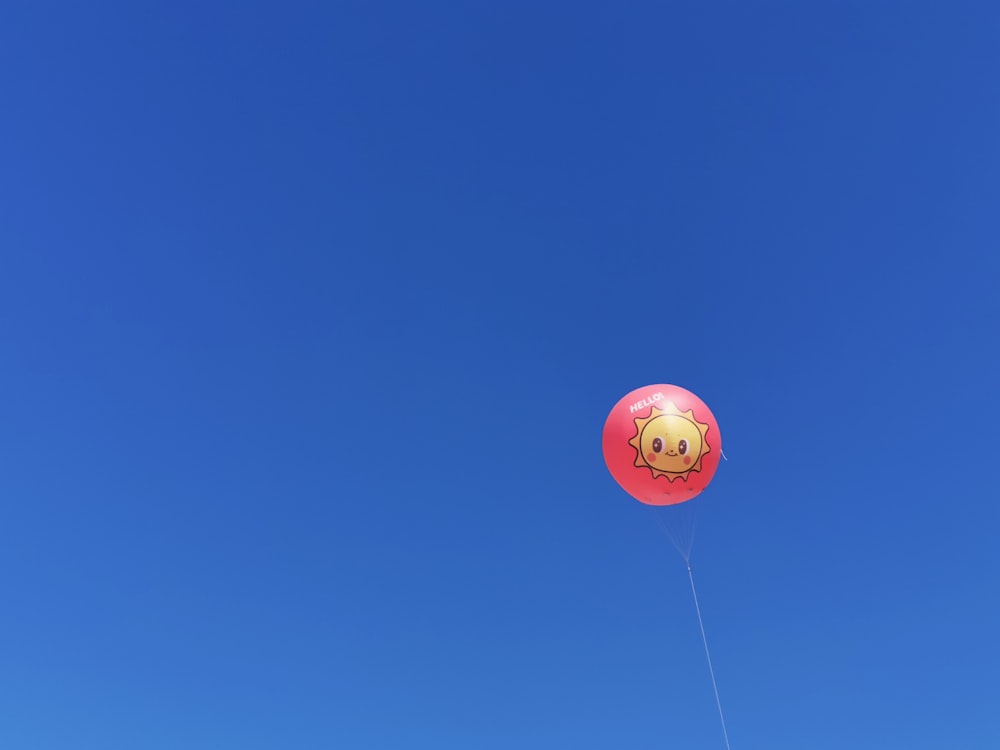 a red balloon with a smiley face on it