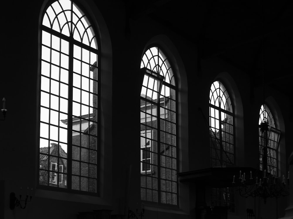 a black and white photo of three windows in a building