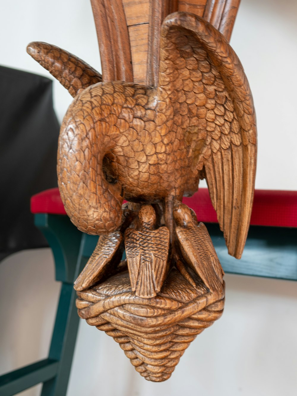 eine Holzskulptur eines Adlers auf einem Stuhl