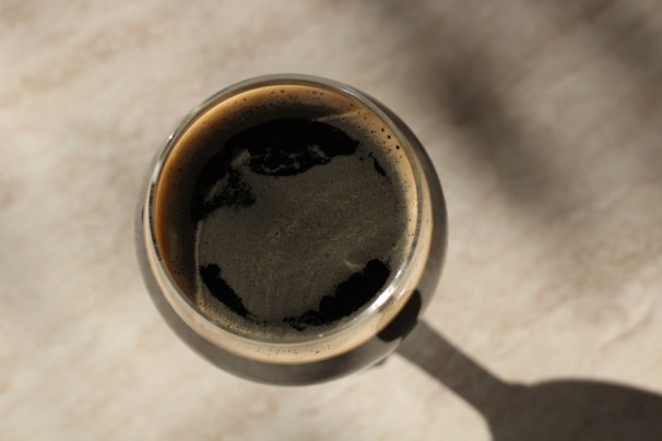 An artistic shot of a dark imperial stout with a frothy head.