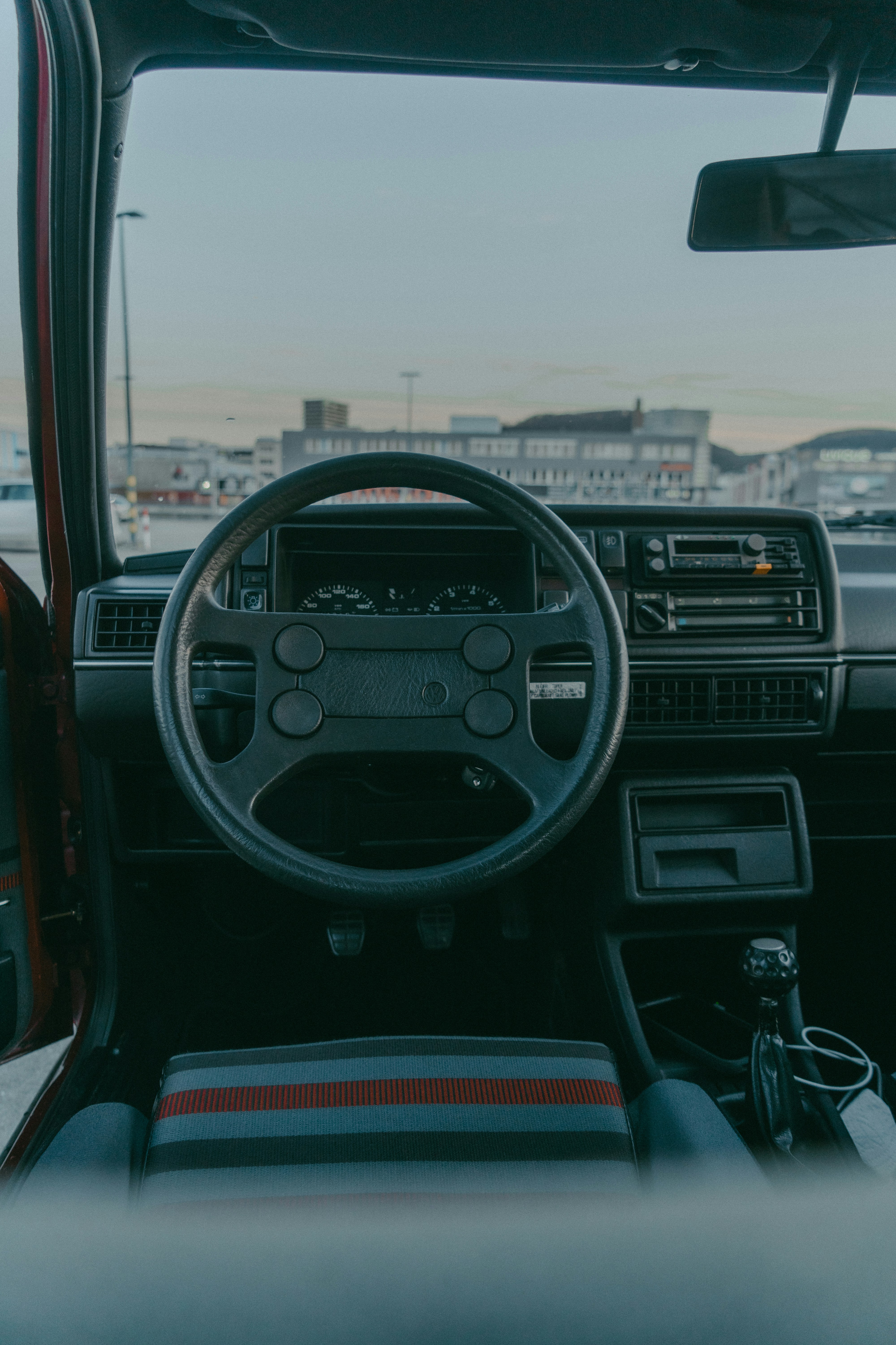 a car dashboard with a steering wheel and dashboard lights