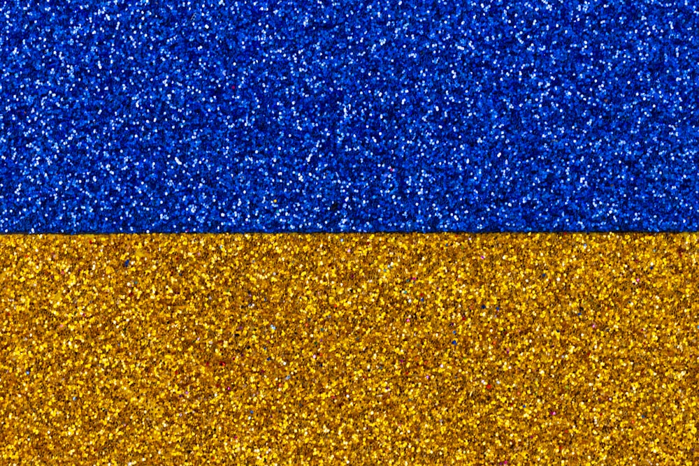 a blue and yellow background with glitter