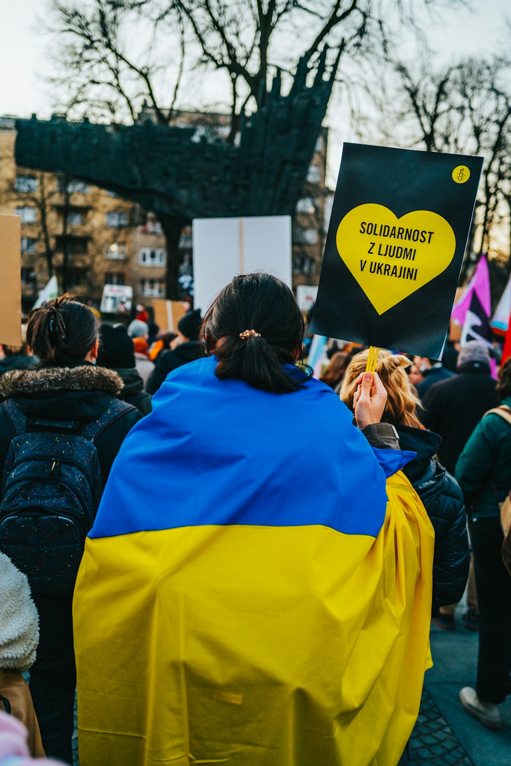 a group of people standing around each other holding signs