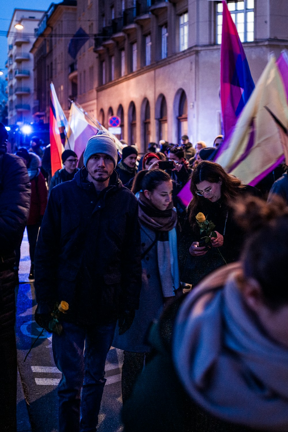 a group of people walking down a street holding flags