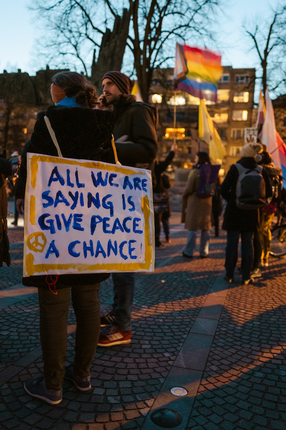 a group of people holding a sign that says all we are saying is give peace