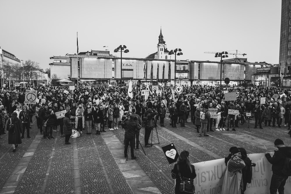 un grand groupe de personnes debout au milieu d’une rue