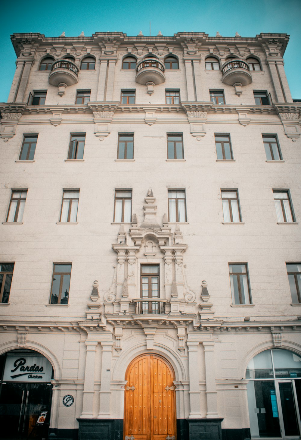 Un edificio alto y blanco con una puerta de madera