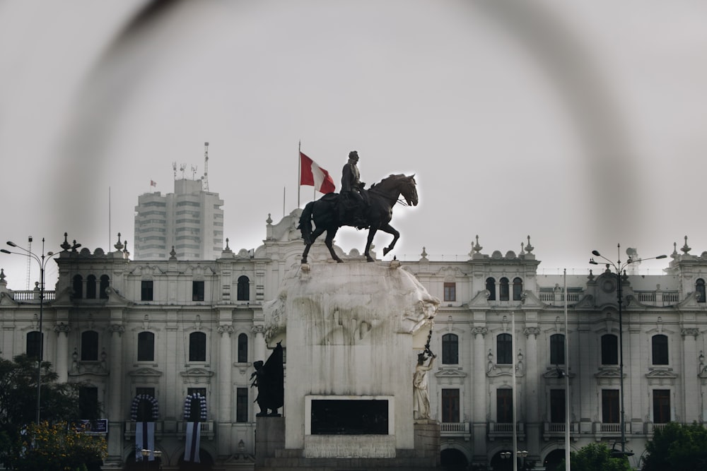 a statue of a man riding a horse in front of a building