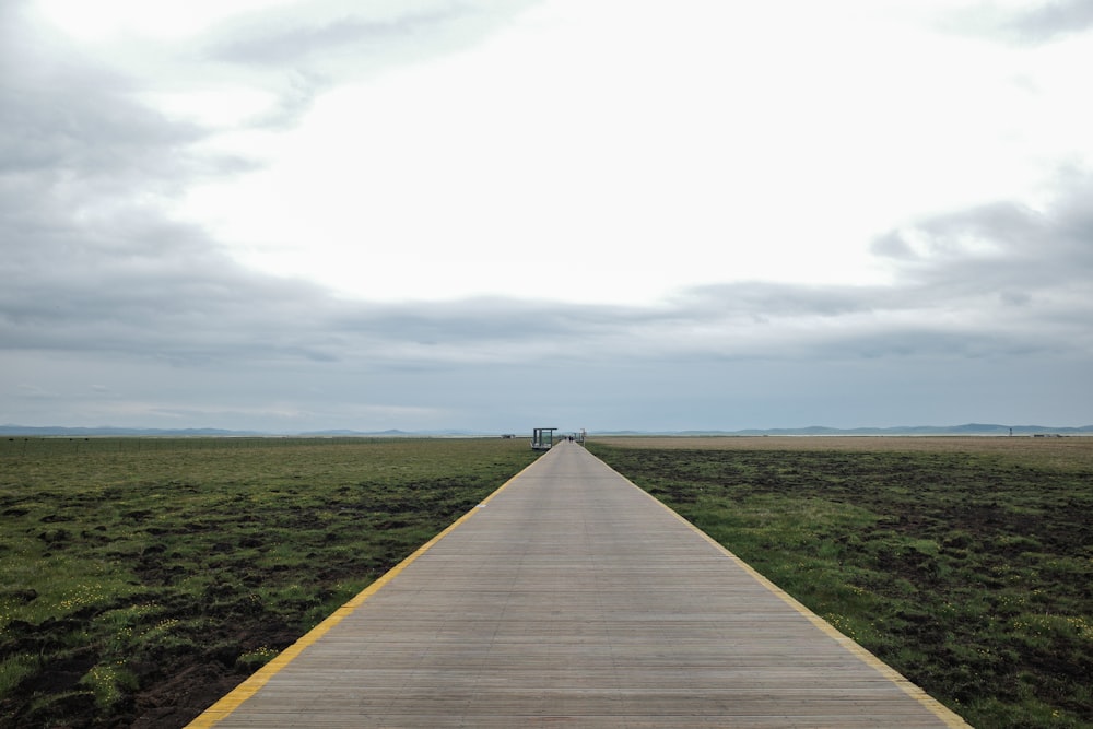 a long wooden walkway in a large field