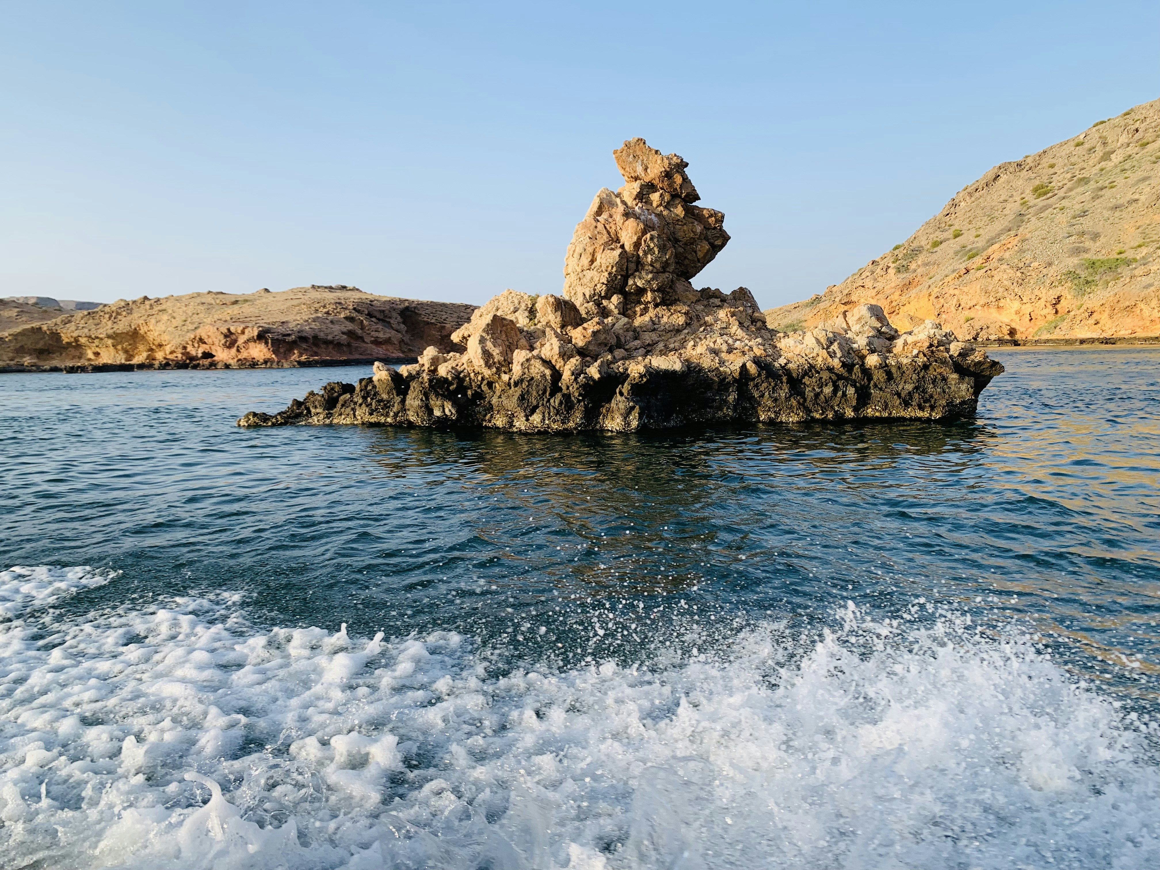 a large rock sticking out of the water