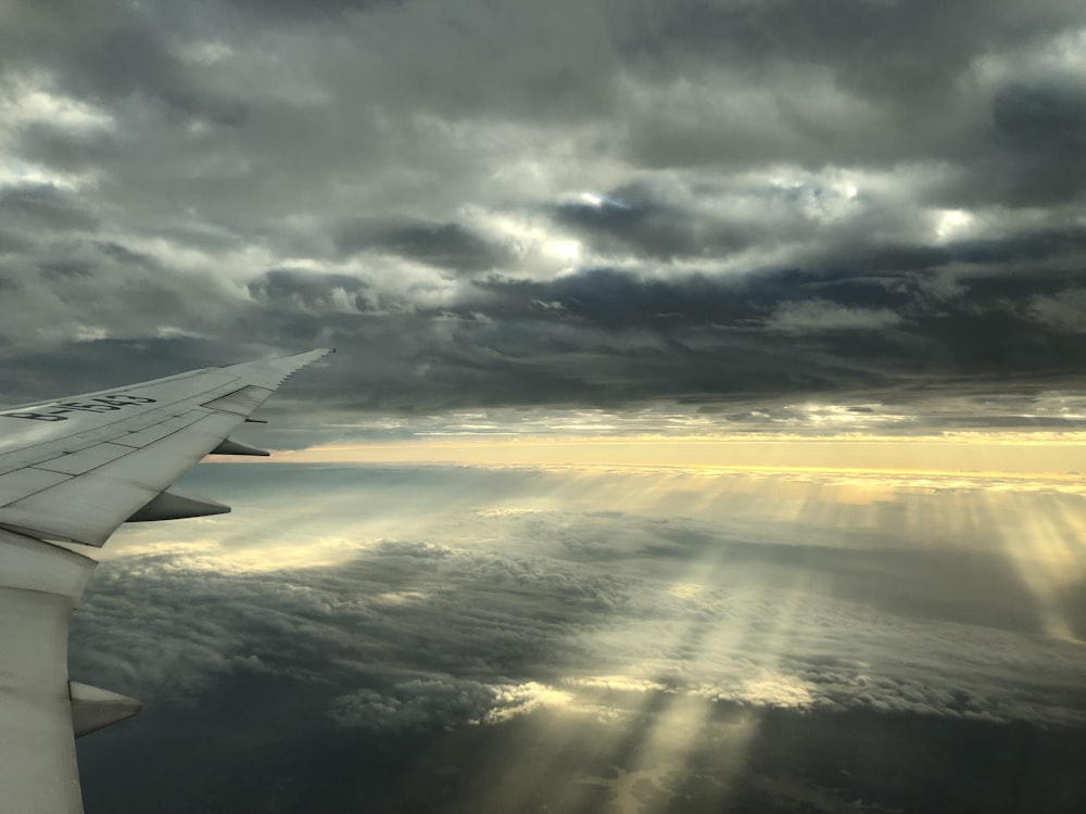 a view of the wing of an airplane as it flies through the clouds