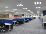 an empty office cubicle with chairs and desks
