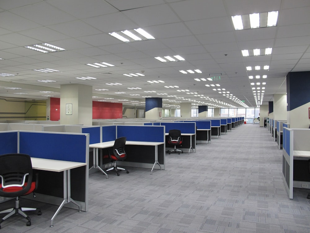 an empty office cubicle with chairs and desks