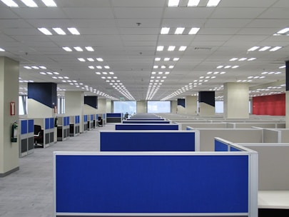 an empty office with blue and white cubicles