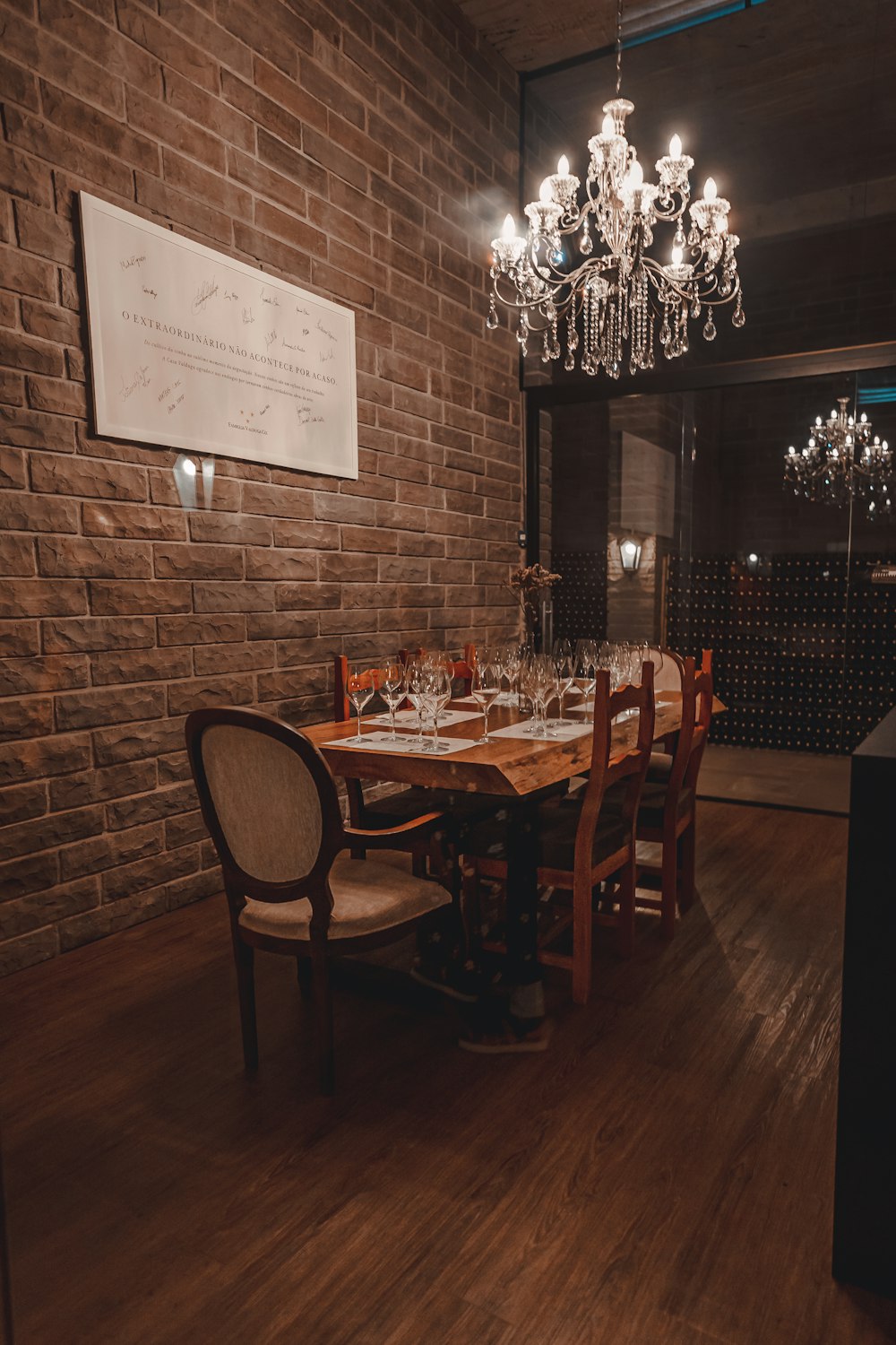 a dining room with a brick wall and a chandelier