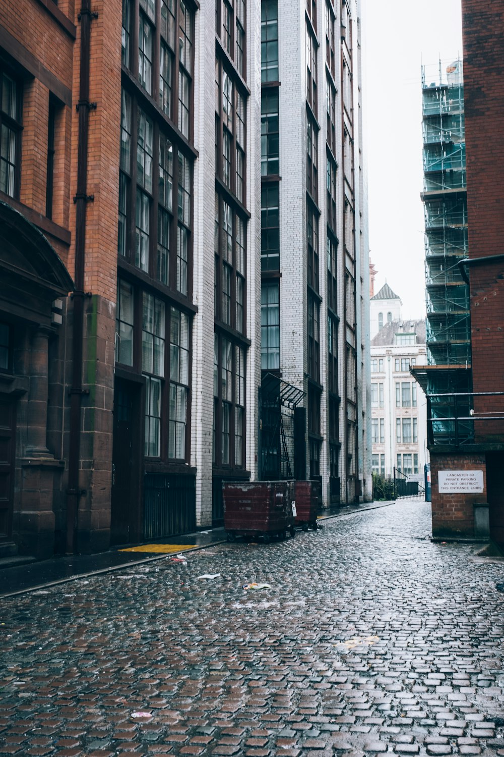 a cobblestone street in a city with tall buildings