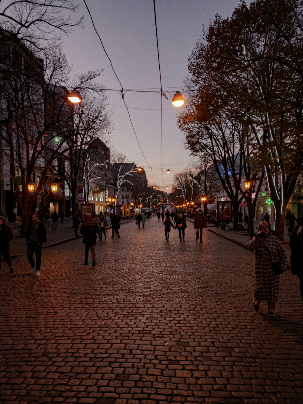 a group of people walking down a street at night