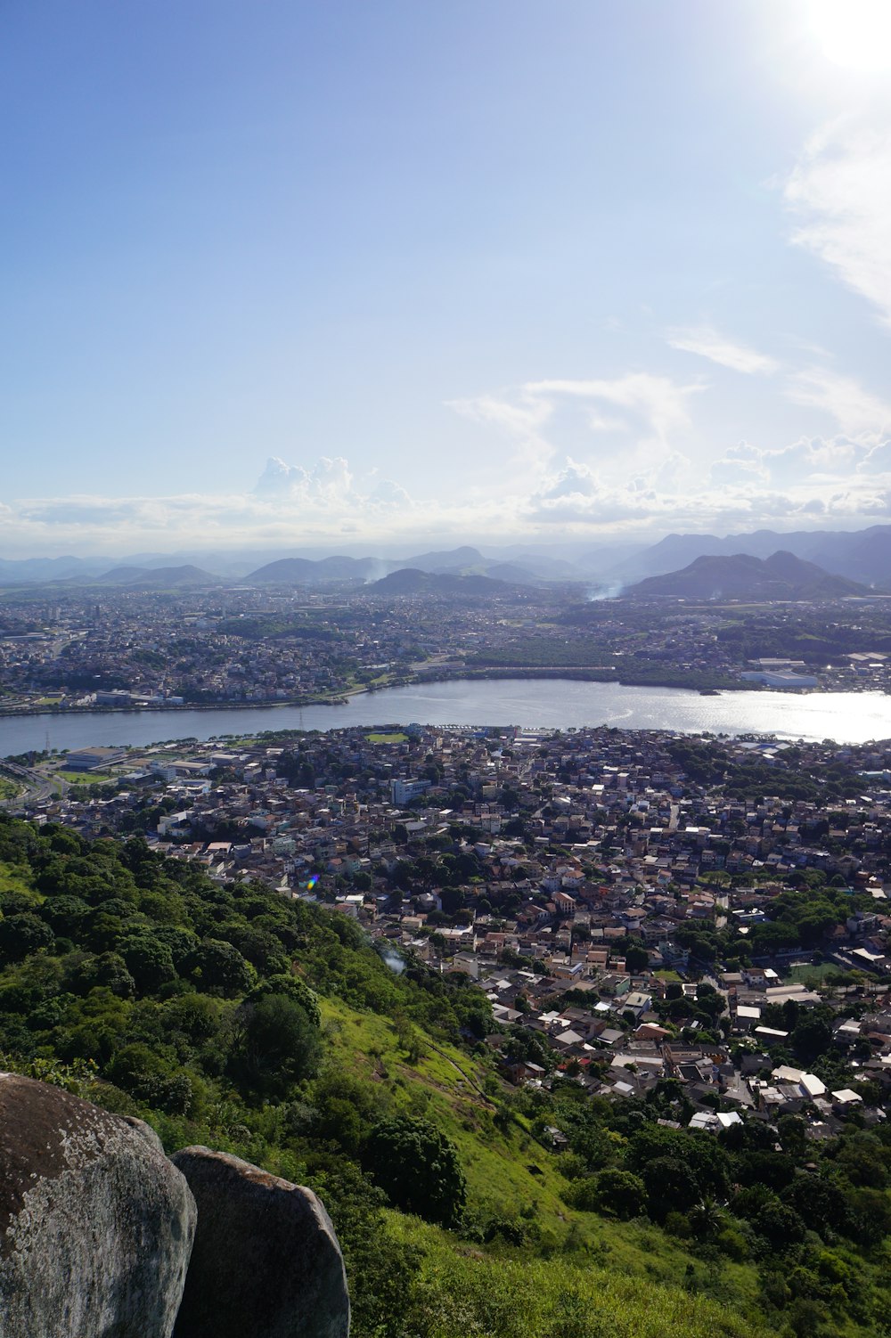 a view of a city and a lake from the top of a hill