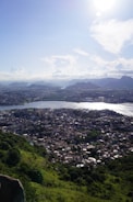 a view of a city and a lake from the top of a hill
