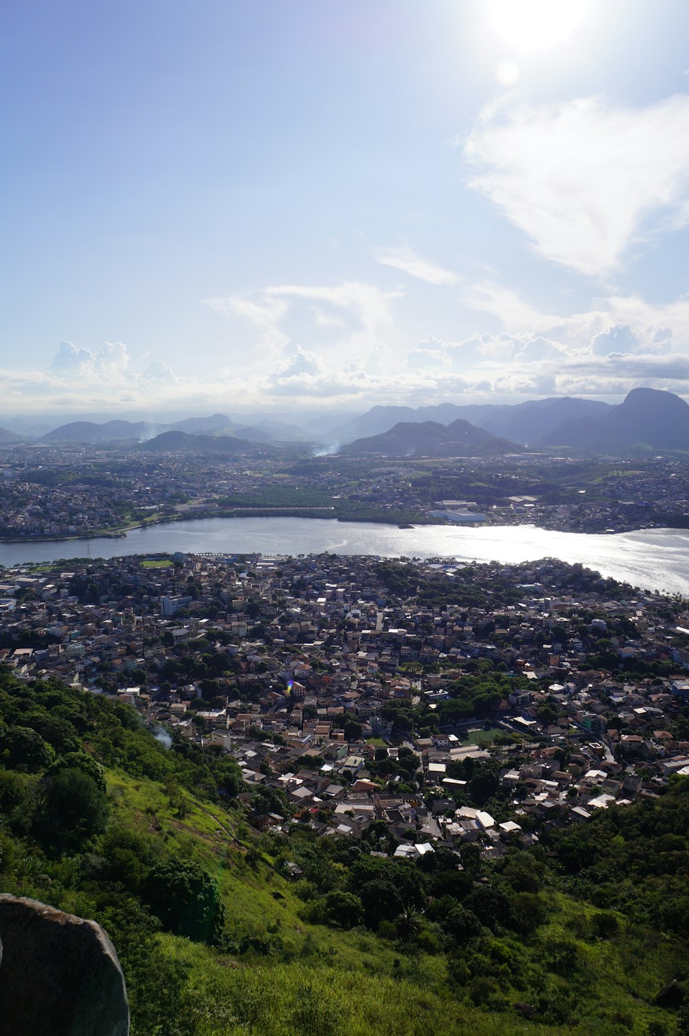 a view of a city and a lake from the top of a hill