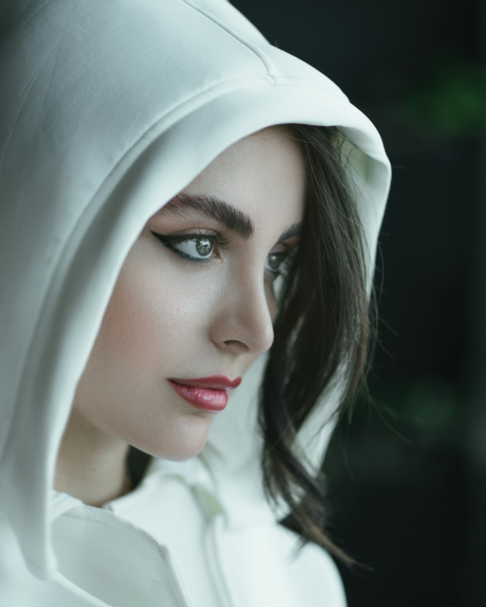 a woman wearing a white hoodie and a red lipstick