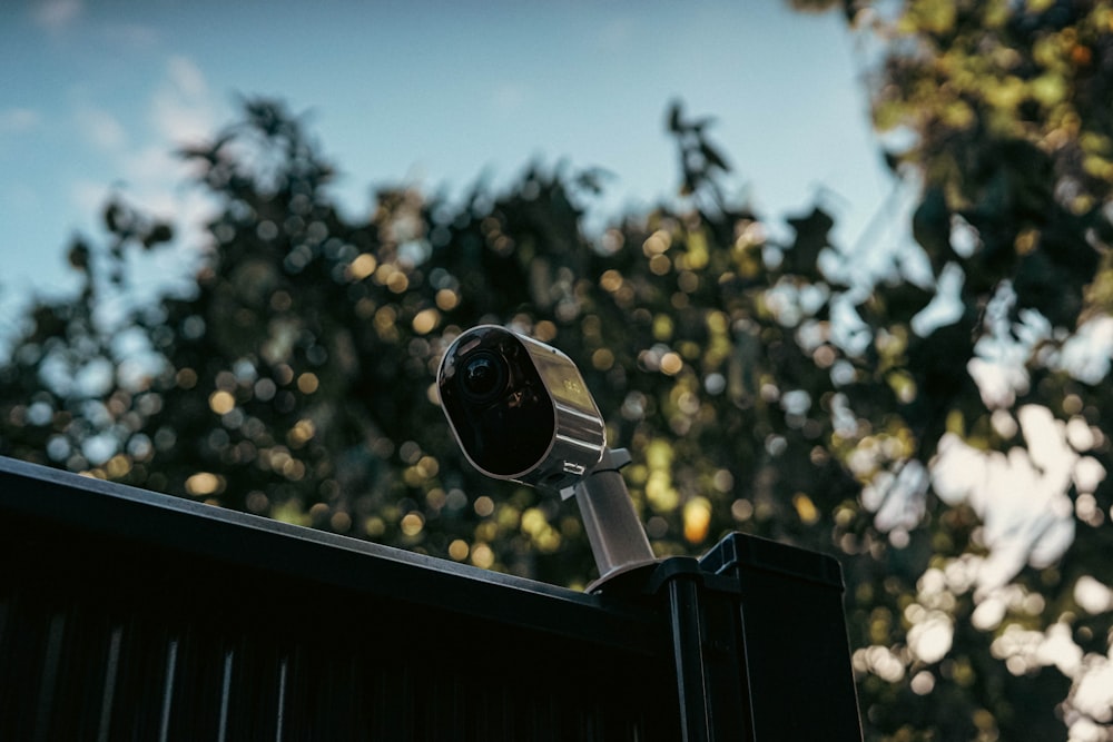 uma câmera montada em cima de uma cerca de metal