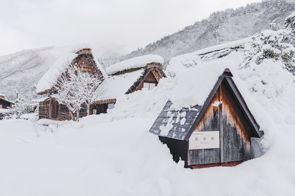 uma montanha coberta de neve com uma pequena cabana no meio dela