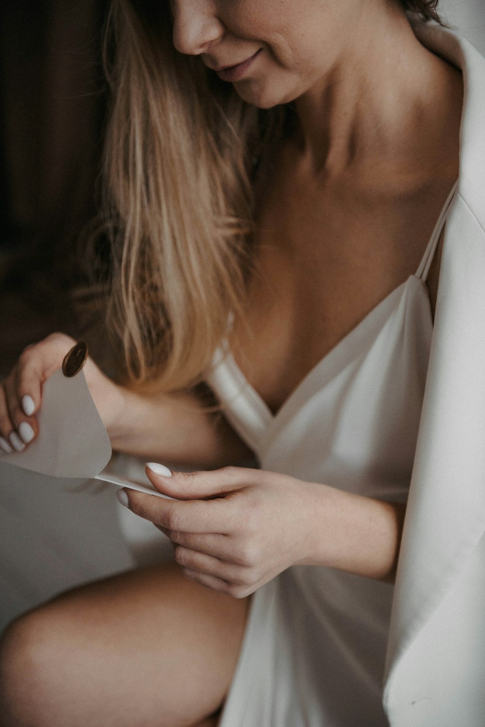 a woman in a white dress holding a piece of paper