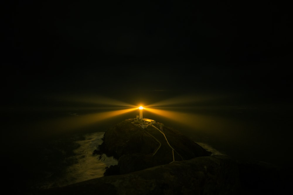 a light shines brightly on a mountain at night