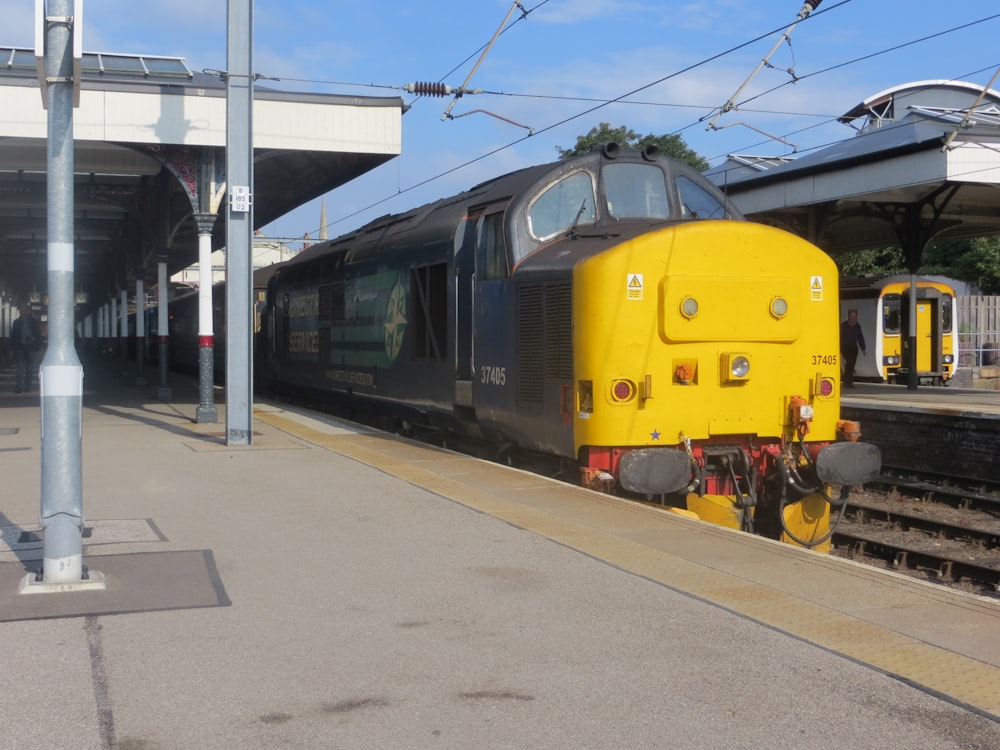 a yellow and black train at a train station