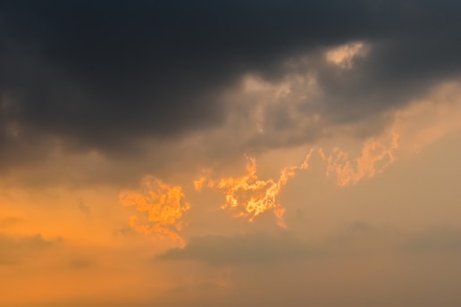 A striking close-up of swirling storm clouds illuminated by a faint sunset glow, capturing the raw power of weather.