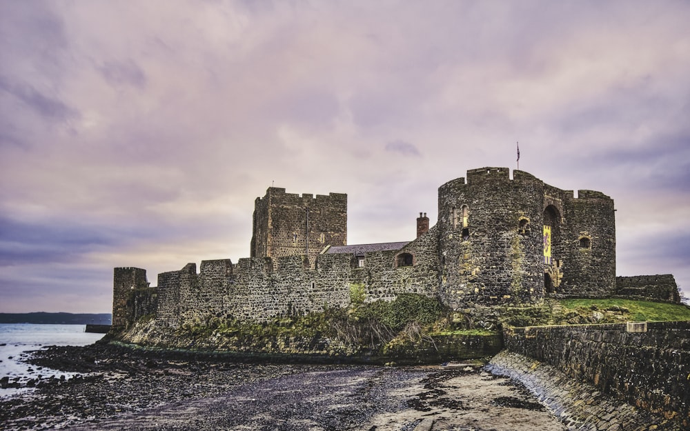 a castle sitting on top of a rocky cliff next to the ocean