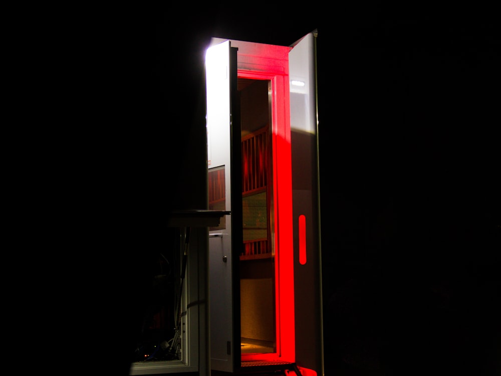 a tall red and white cabinet in the dark