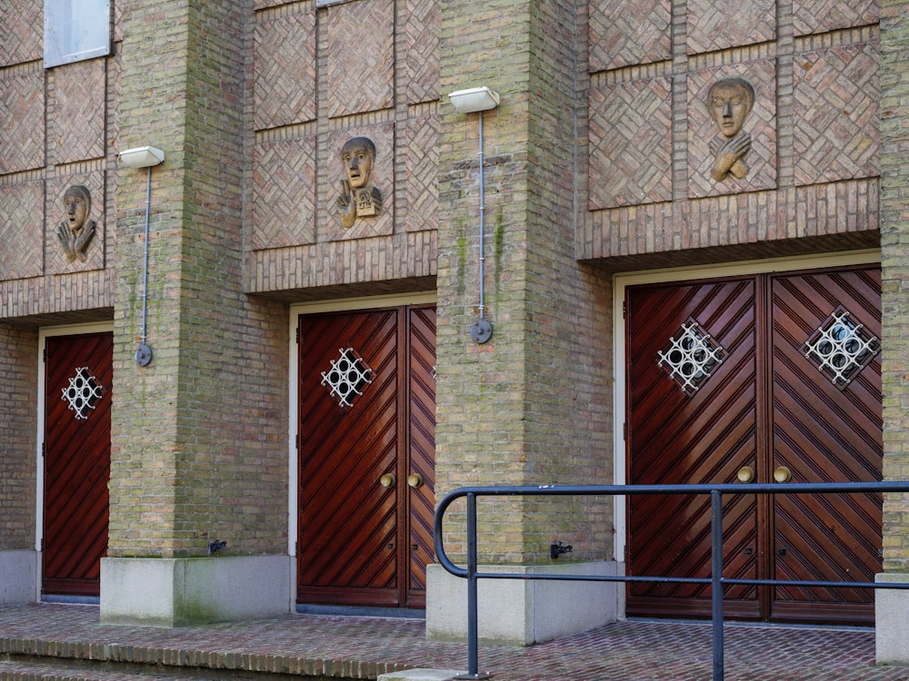 a couple of brown doors sitting on the side of a building