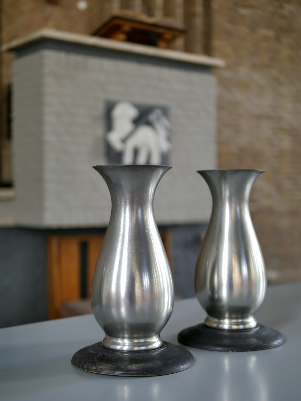 a couple of silver vases sitting on top of a table