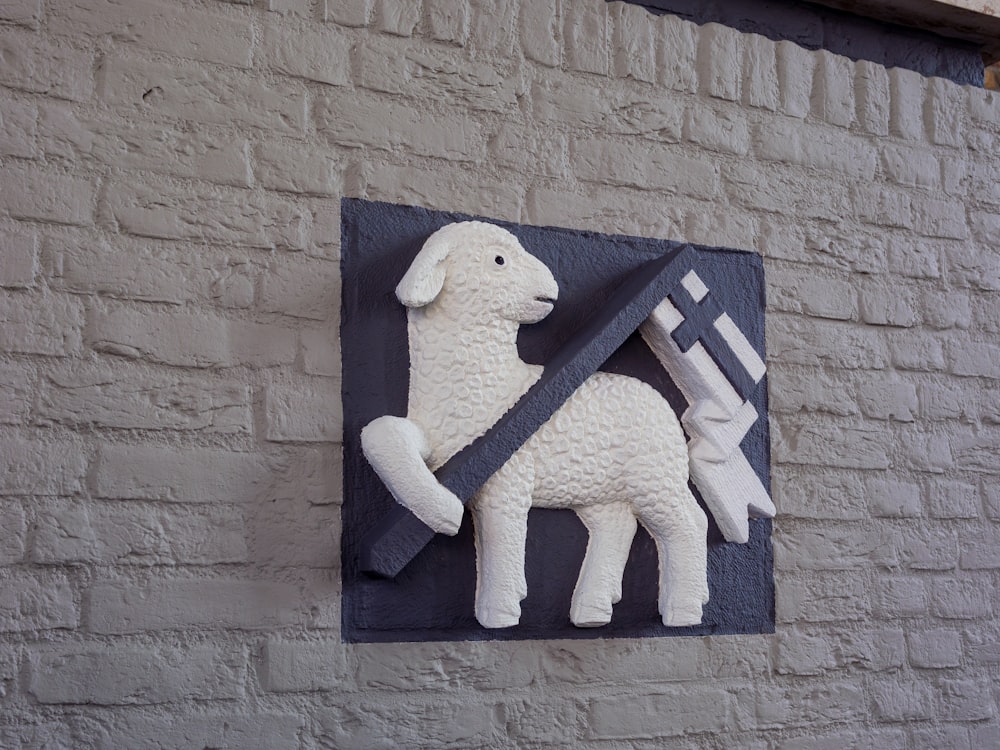 レンガの壁に剣を持つ羊の彫刻
