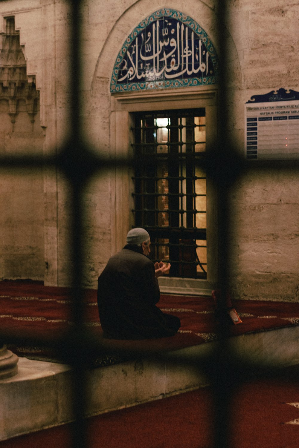 a man sitting on the ground in front of a building