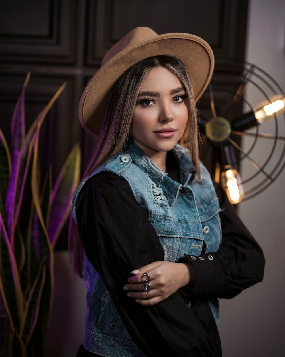 a woman wearing a hat and denim jacket