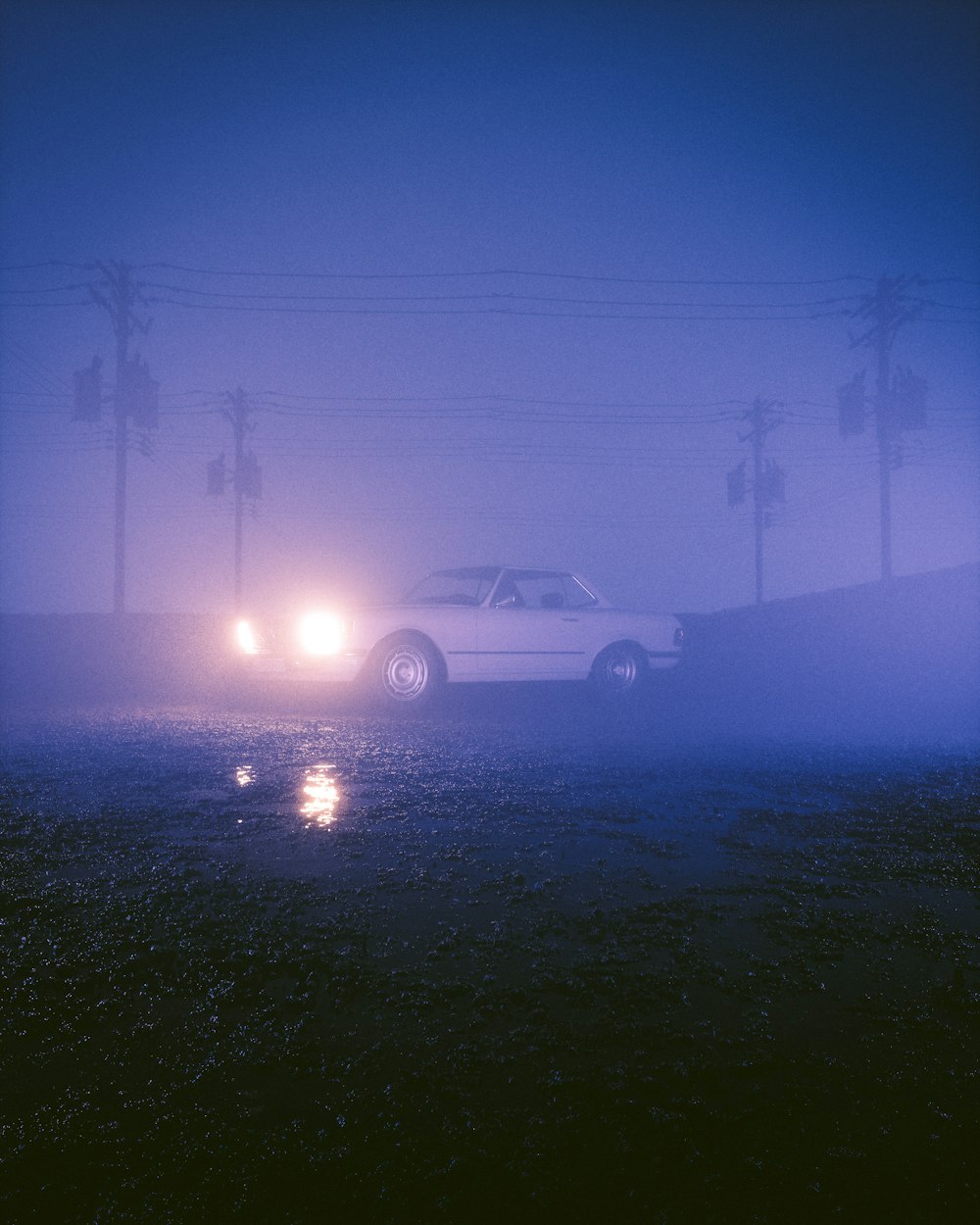 a car driving on a foggy road at night