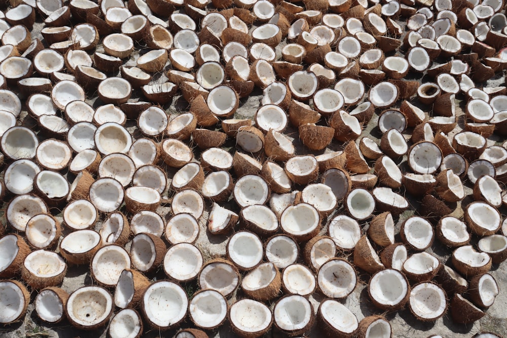 Una pila de cocos cortados sentados sobre un suelo de cemento