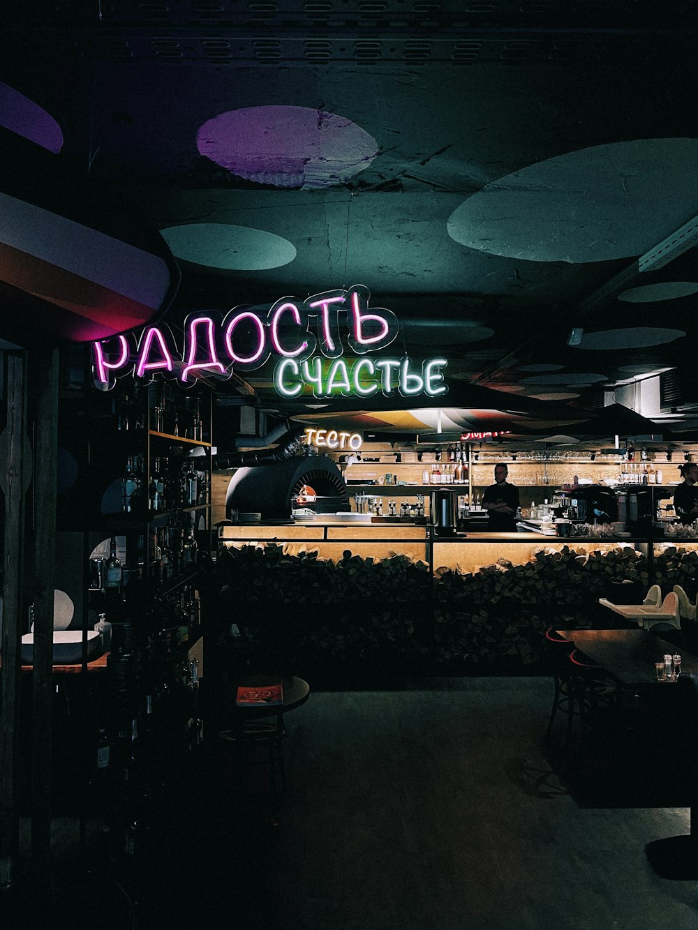 a restaurant with a neon sign above the counter