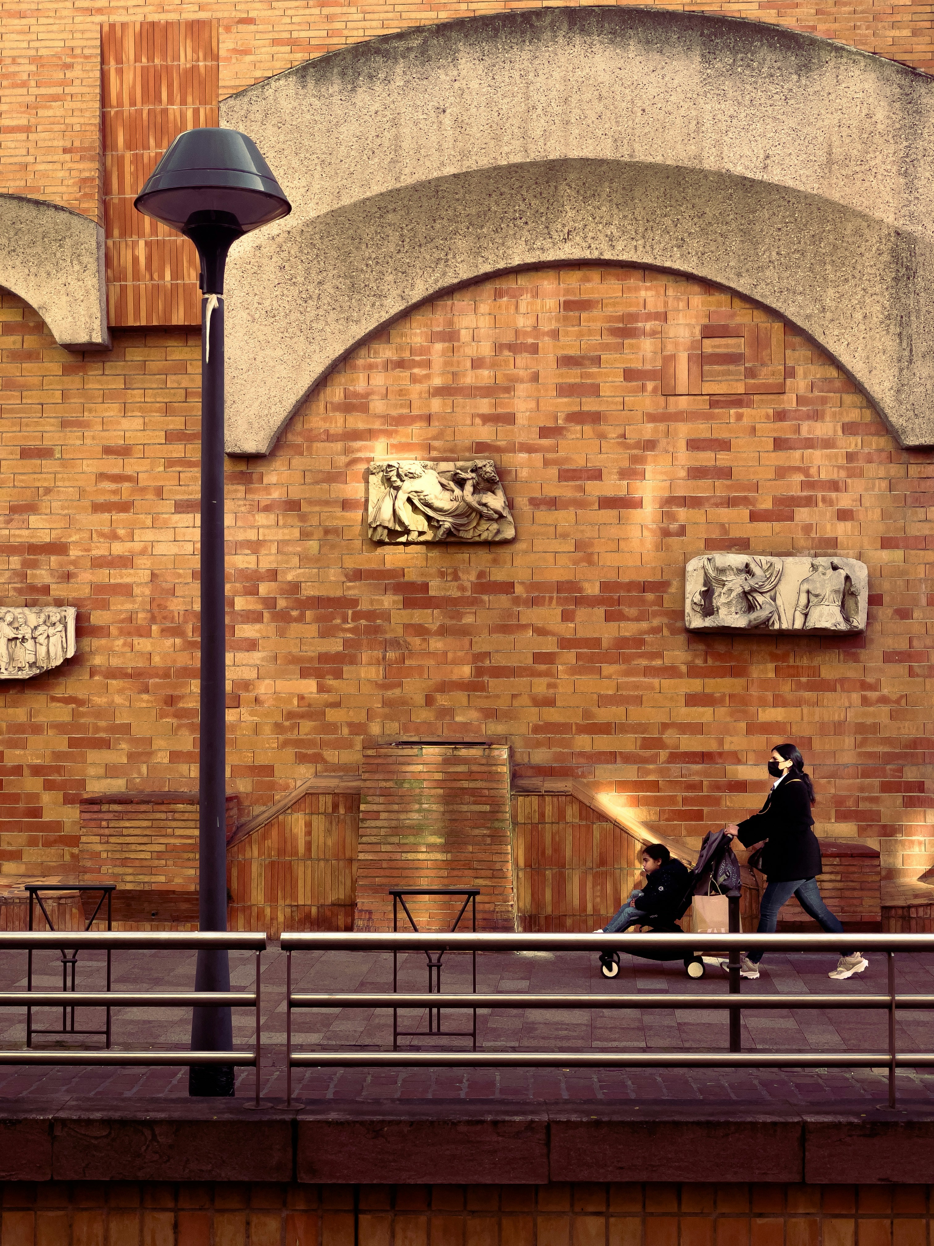 a couple of people walking down a street next to a building