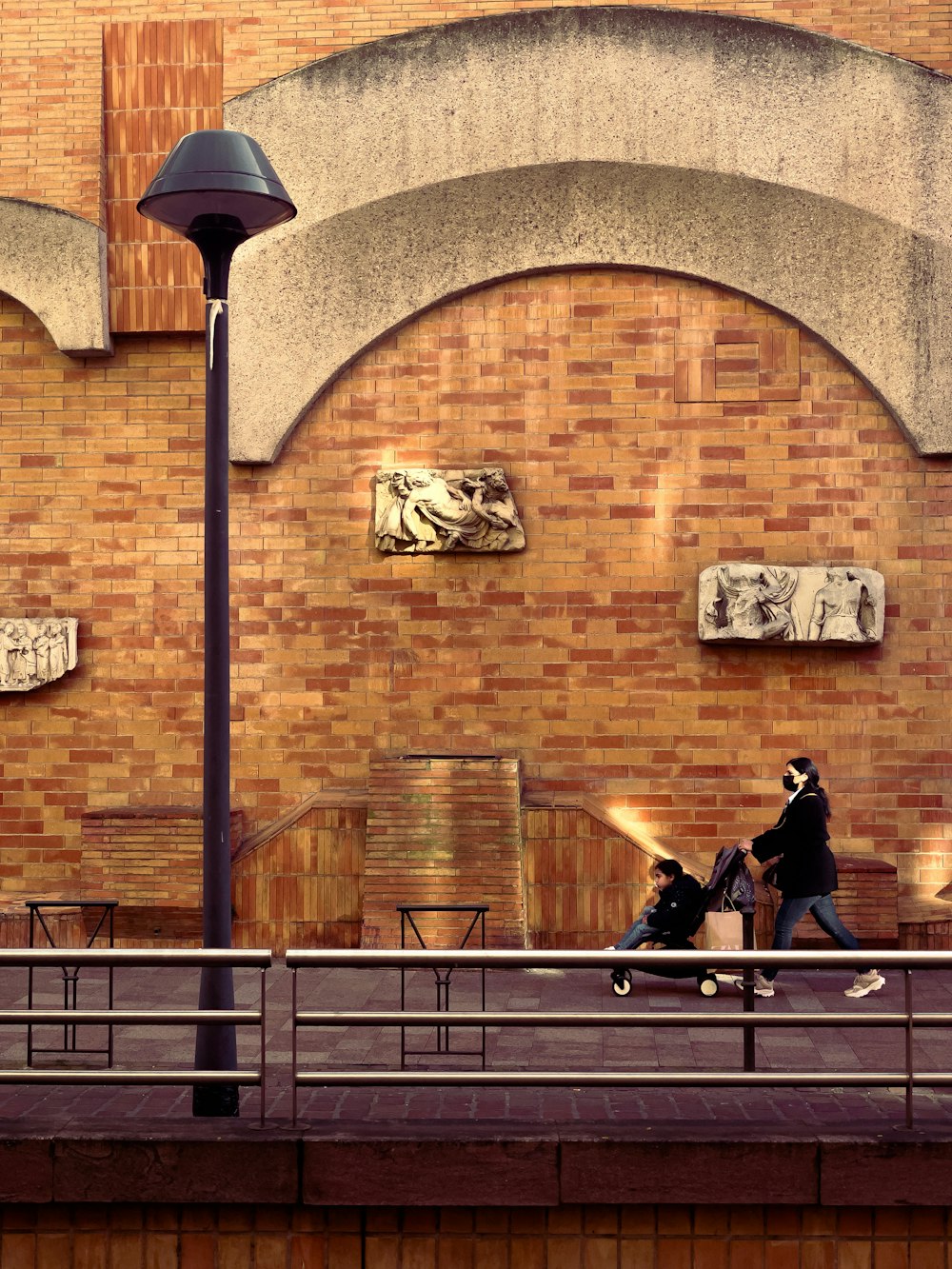 a couple of people walking down a street next to a building