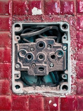 Electrician repairing a wall socket with tools in a cozy home setting.